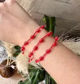 Pulsera hecha a mano con 7 nudos, en color rojo, diseñada como amuleto de protección.