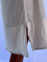 Vestido playero blanco de algodón con pespuntes azules, corte recto y sin mangas.