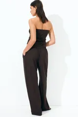 Pantalón de vestir marrón de punto con pinzas, tiro alto con cintura elástica, bolsillos al bies y piernas amplias con raya adelante.