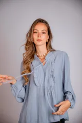 Camisa celeste con volados en cuello y en la parte delantera, con cordones.