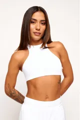 Top deportivo blanco de cuello alto, sin mangas y corte ajustado.
