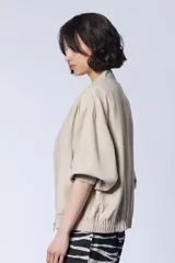 Campera bomber color beige con cierre frontal y mangas 3/4.