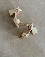 Sandalias doradas de cuero vacuno con taco bloque de 8cm y tira al tobillo.