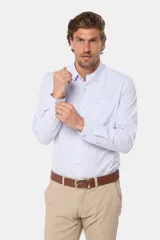 Camisa celeste a rayas verticales, de manga larga con opción de arremangar, corte slim fit y bolsillo en el pecho. Confeccionada en algodón.