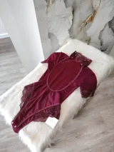 Body entallado de lycra color bordo con detalles en microtul y encaje. Con cuello alto y espalda descubierta.
