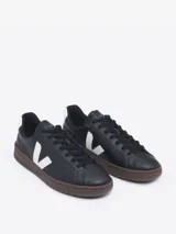 Zapatillas Veja modelo Urca, color negro con logo lateral en blanco y contrafuerte blanco con logo. Suela marrón.