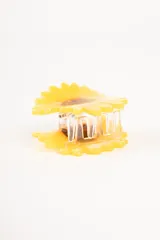 Pinza para el pelo con forma de girasol amarillo y centro marrón.