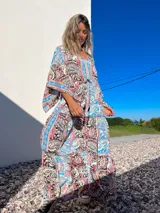 Túnica larga de mangas anchas con estampado de arabescos en tonos celeste, rosa, negro y beige.