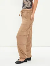 Pantalón negro de corte holgado con cintura elástica ajustable con cordón, bolsillos laterales y bolsillos tipo cargo en los laterales de las piernas.