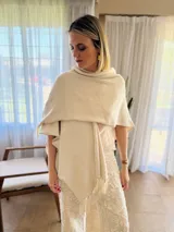 Ruana tejida color arena con flecos.