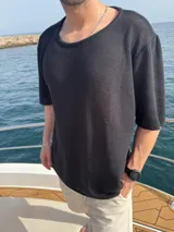 Buzo tejido negro de manga corta y cuello redondo.