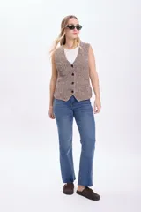 Chaleco de punto lurex color taupe con escote en V y cierre frontal con botones.