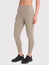 Calza deportiva color beige, tiro alto, con bolsillos laterales y banda de silicona en la cintura.