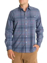 Camisa de franela de algodón orgánico a cuadros en tonos azul, gris y verde. Tiene cuello camisero, manga larga, un bolsillo en el pecho y cierre con botones.