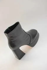 Botines negros de cuero con plataforma y tacón cuadrado. Cierre con cremallera lateral.