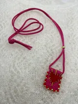 Collar con dije rectangular bordado con un corazón rojo y detalles de mostacillas de colores.