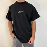 Remera negra de algodón con estampado de un tiburón en color naranja y tipografía en blanco.