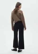 Pantalón culotte de pana negra, tiro alto, con cierre de cremallera y botón, trabillas, dos bolsillos de parche delanteros y dos traseros. Diseño crop.