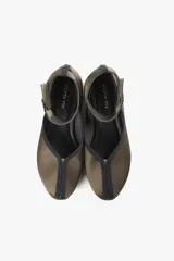 Zapato color marrón con base deportiva, pulsera al tobillo ajustable con hebilla metálica y puntera redondeada.