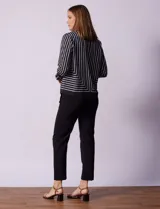 Blusa de gasa estampada a rayas verticales blancas y negras, marca Sioni. Tiene espalda con abertura y botón, y mangas largas con puño y botón.