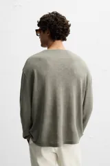 Jersey color beige de punto tejido en hilatura ligera de lino, con cuello redondo, manga larga y acabados en rib.