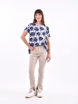 Remera blanca con estampado de flores y hojas en tonos pastel.