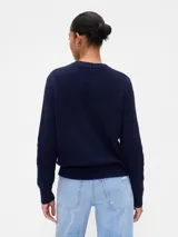 Buzo de algodón negro con cuello redondo, manga larga y tejido de punto con trenzas y calados en el frente.