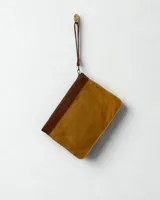 Sobre de cuero color ocre con aplique de cuero marrón en la parte superior y correa de mano desmontable.