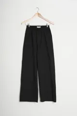 Pantalón de corte amplio en color beige, con cintura elástica y bolsillos laterales.