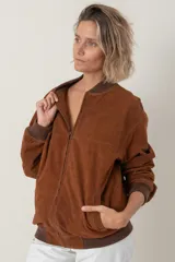 Campera estilo bomber color marrón, unisex, confeccionada en cuero tipo antílope, con cierre frontal y bolsillos laterales.