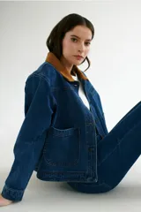 Chaqueta de jean azul con cuello de pana color camel, corte recto y bolsillos frontales.