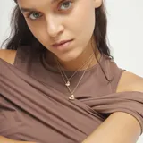 Collar doble de aleación de metales bañada en oro 18k, con dos cadenas de eslabones finos y dos dijes de corazón colgantes de diferente tamaño.