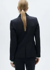 Blazer entallado color azul marino, con cuello de solapa de muesca, manga larga con puños abotonados, dos bolsillos de ribete delanteros, un bolsillo de ribete en el pecho, cierre frontal con botones, abertura posterior en el bajo y forro interior.
