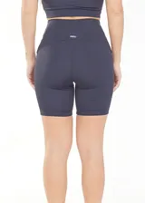 Calza biker deportiva de cintura alta color gris, con compresión, recortes y tejido transpirable de secado rápido.