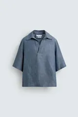 Camisa azul de lino con cuello polo, corte holgado y mangas cortas.
