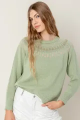 Sweater tejido color verde agua con cuello redondo y diseño de ochos con detalles rosados en la parte superior.