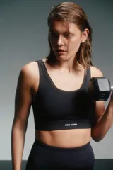 Top deportivo negro con breteles finos y banda inferior con el logo de la marca Caro Cuore.