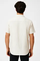 Camisa de algodón a rayas verticales celestes y blancas, con cuello camisero y botones.