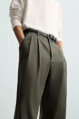 Pantalón verde oliva de corte amplio con pliegues en la parte delantera, bolsillos laterales y traseros de ojal.