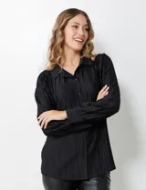 Camisa negra de satén plisado con cuello con solapa y abertura central con botones.