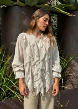 Camisa beige de manga larga con volados frontales y puños elastizados.
