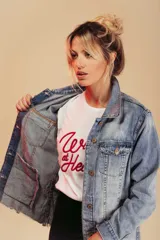 Remera blanca de algodón con cuello redondo y estampado frontal con la frase "Wild at Heart" en letras rojas.