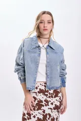 Campera de jean celeste, corte cropped, con cuello clásico, cierre frontal con cremallera, mangas largas con puños elásticos y bolsillos laterales.
