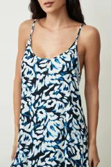 Vestido corto blanco de tirantes finos, con escote redondo y corte holgado tipo camisola, con un pequeño volante en el ruedo.