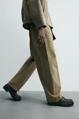 Pantalón de jean color verde oliva, corte balloon fit, con cinco bolsillos, efecto lavado y costuras giradas hacia adelante.