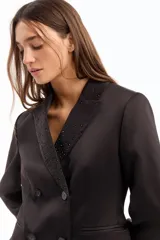 Blazer cruzado negro con calce adherente y detalle de hot fix en solapa, cuello y manga.
