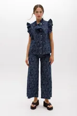 Pantalón jean wide leg de tiro alto, color azul denim, con ruedo desflecado y bolsillos delanteros y traseros.