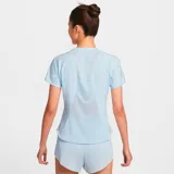 Remera deportiva Nike Dri-Fit Swift para mujer, color celeste con logo reflectivo en el pecho.