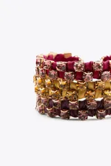 Pack de tres pulseras de tejido a color con aplicación de joyas combinadas a contraste y cierre de mosquetón. Incluye una pulsera fucsia, una púrpura y una amarilla.