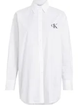 Camisa blanca de algodón con cuello clásico, cierre frontal con botones, manga larga y corte oversize. Presenta un monograma bordado en el pecho.